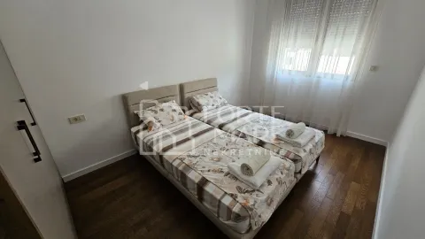 Spavaća soba sa dva odvojena kreveta i drvenim podom. - image 10
