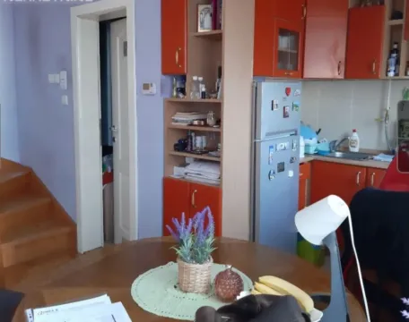 Kuhinja sa trpezarijskim stolom i narandžastim kuhinjskim elementima. - image 4