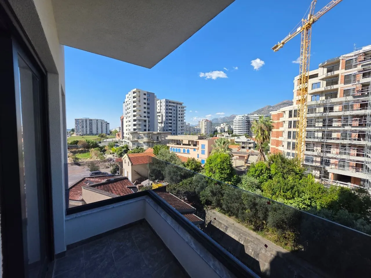 Pogled sa balkona na gradsko naselje i zgrade u izgradnji.