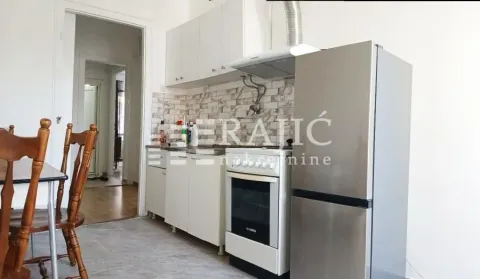 Small bright kitchen with white cabinets and a dining table. - image 4