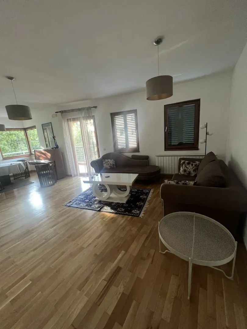 Bright and spacious living room with wooden flooring and seating furniture.