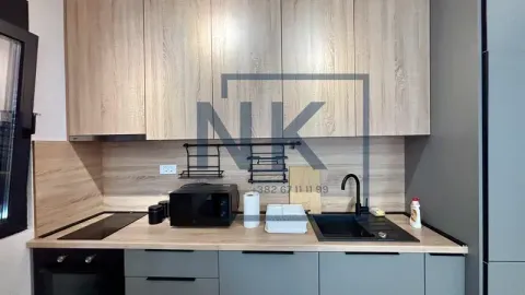 A view of a modern equipped kitchen with wooden elements and a black sink. - image 7