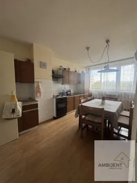 Kuhinja sa drvenim elementima i trpezarijskim stolom pored prozora. - image 4