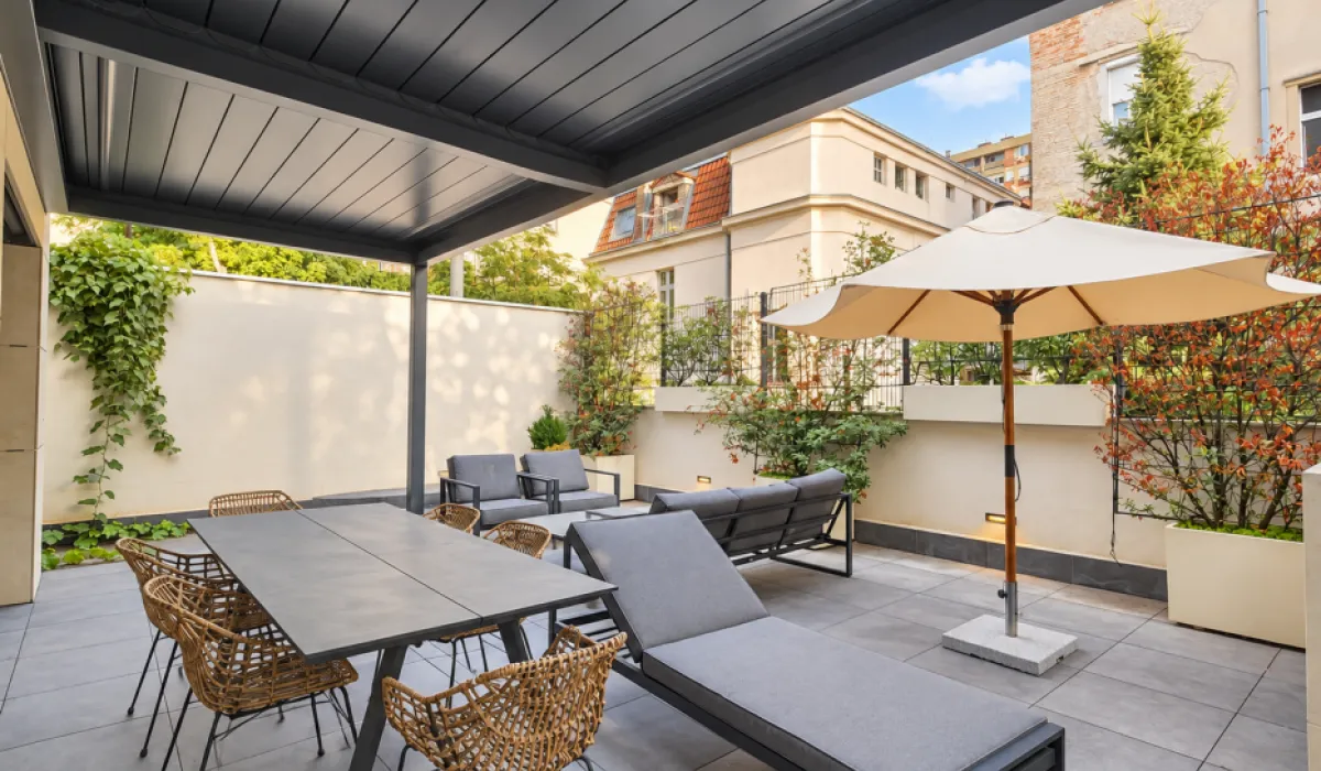 Spacious terrace with seating furniture, sun loungers, and a dining table.