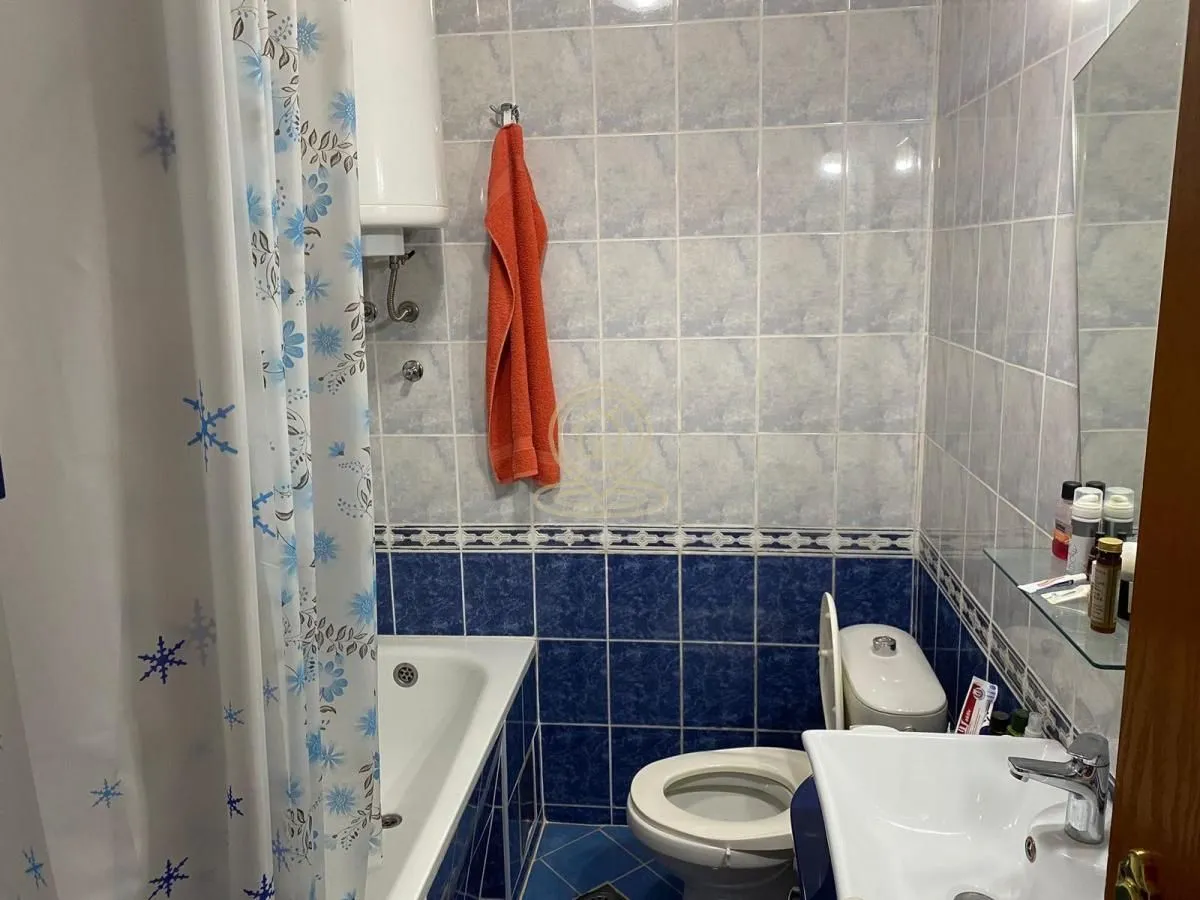 Small bathroom with a bathtub, toilet, and washbasin.