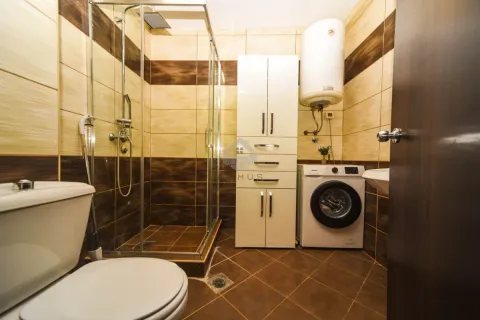 Kupatilo sa tuš kabinom, WC šoljom, veš mašinom i bijelim ormarićem. - image 8