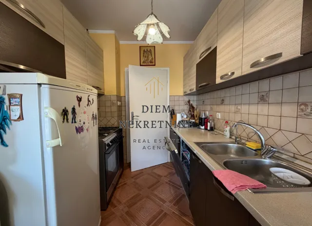 Small kitchen with wooden cabinetry and appliances.
