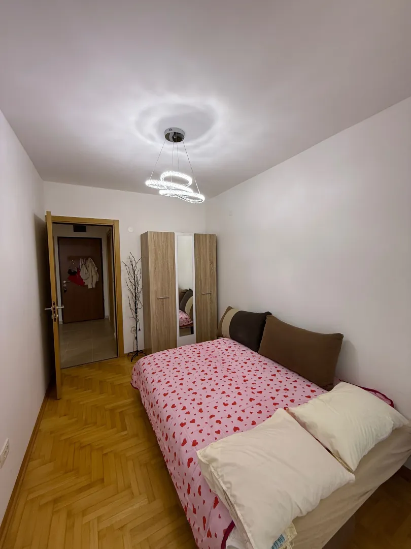 Bedroom with a double bed, wardrobe, and wooden flooring.