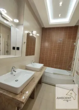 Modern bathroom equipped with two washbasins and a bathtub. - image 20