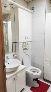 Kupatilo opremljeno umivaonikom, WC šoljom, ormarićem sa ogledalom i tuš kabinom. - image 3