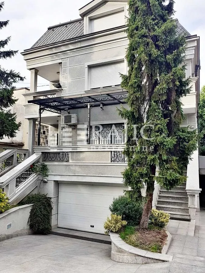 Exterior of a multi-family house with a yard and garage door.