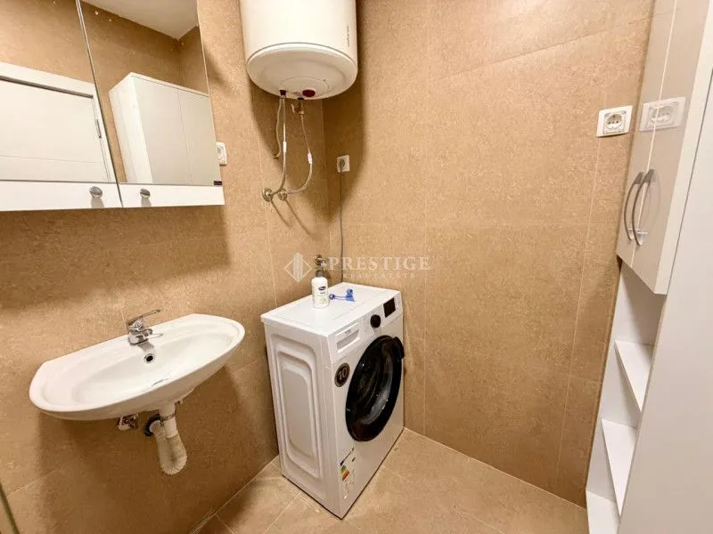 Smaller bathroom with a sink, washing machine, and water heater.
