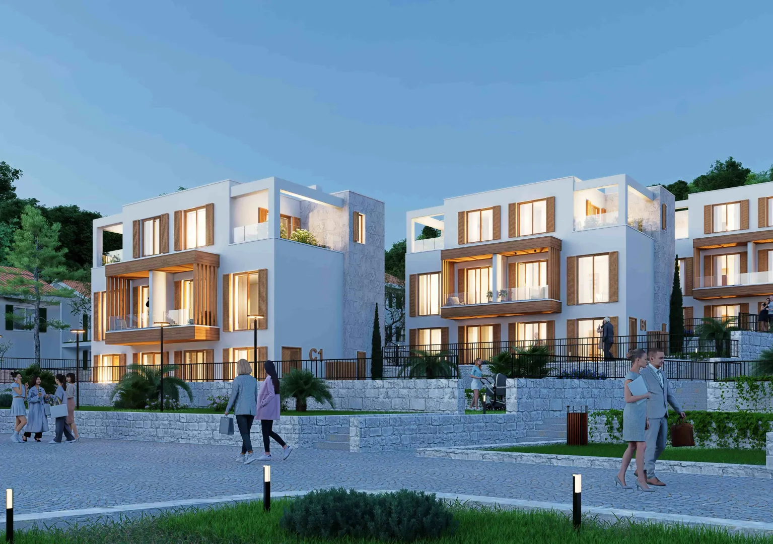 Eksterijer modernih stambenih zgrada sa uređenim dvorištem i šetalištem u sumrak.