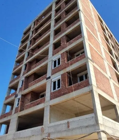 Exterior view of a multi-story residential building under construction.