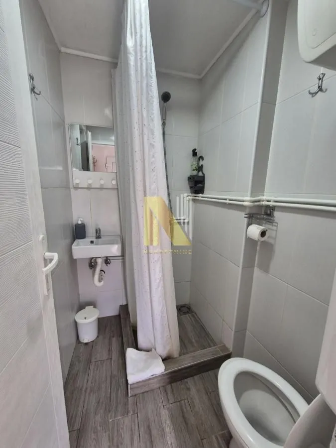 Manje kupatilo sa tuš kabinom, umivaonikom i toaletom.
