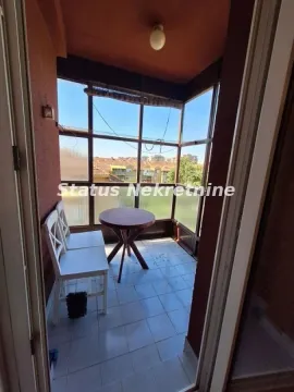 Zastakljeni balkon sa malim stolom i stolicama. - image 6