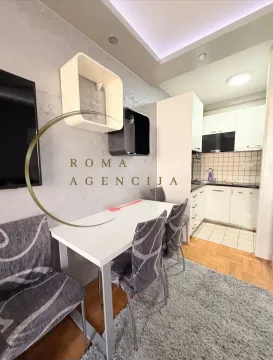 Small kitchen with a dining area and white cabinets. - image 4