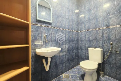 Bathroom tiled in blue with a sink and toilet. - image 5