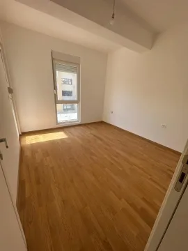 Prazna neopremljena prostorija sa drvenim podom i prozorom. - image 7