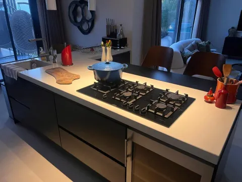 Modern kitchen with an island, stove, and kitchen utensils. - image 19