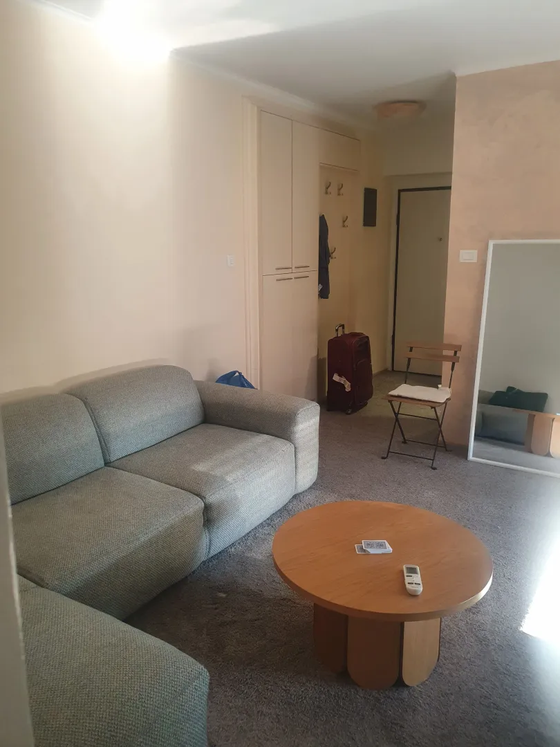 Dnevna soba sa garniturom, stočićem i ogledalom.