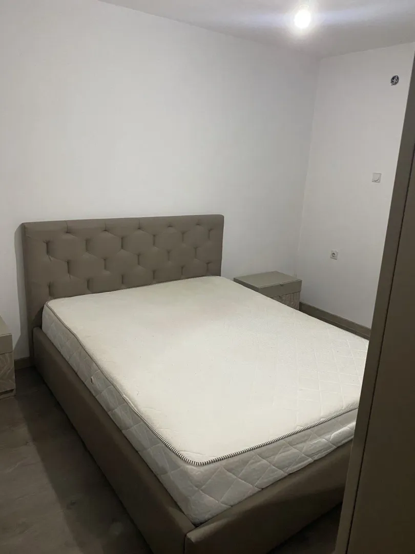 A simple bedroom with a double bed and nightstands.