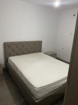 A simple bedroom with a double bed and nightstands. - image 4