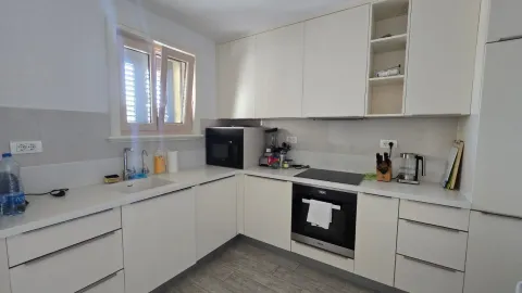 Svjetla kuhinja sa bijelim elementima i ugradnim uređajima. - image 8