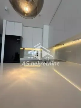 Modern white kitchen with under-cabinet lighting and a white kitchen island counter. - image 7