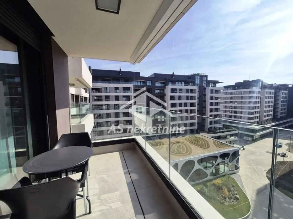 Modern furnished balcony with a table and chairs overlooking the neighborhood.