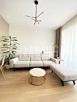 Bright living room with a sofa and hardwood floors. - image 2