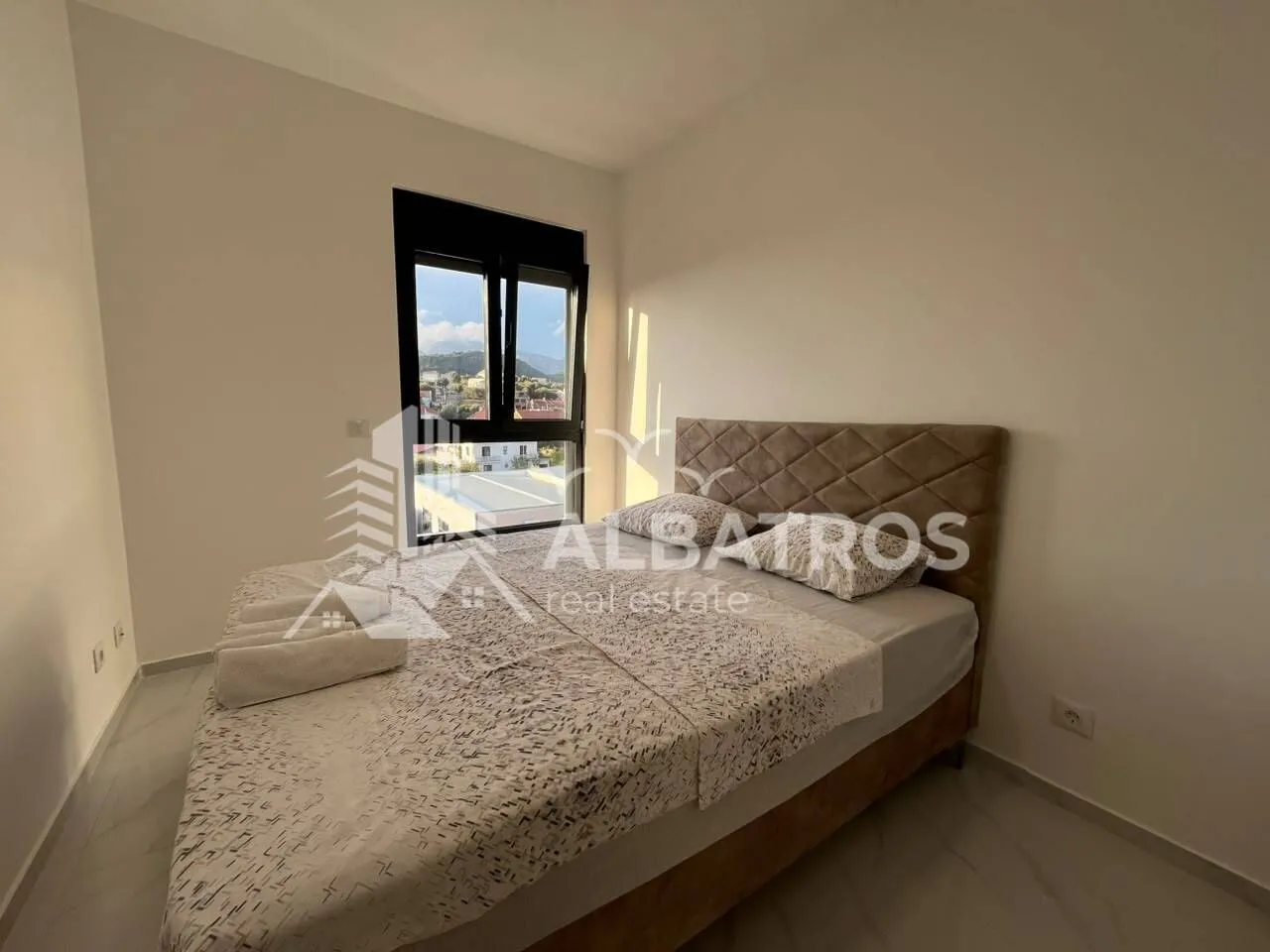 Furnished bedroom with a double bed and a window.