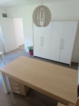 Bright room with a wooden table and a white wardrobe. - image 10