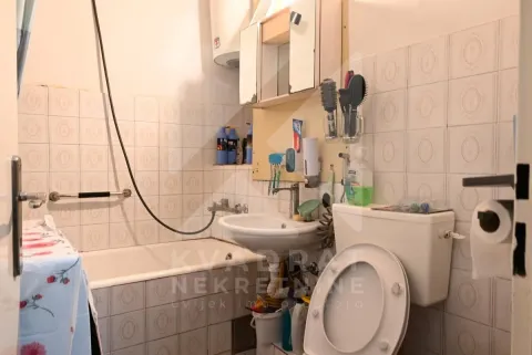 Manje kupatilo sa kadom, umivaonikom i toaletom, obloženo keramičkim pločicama. - image 14