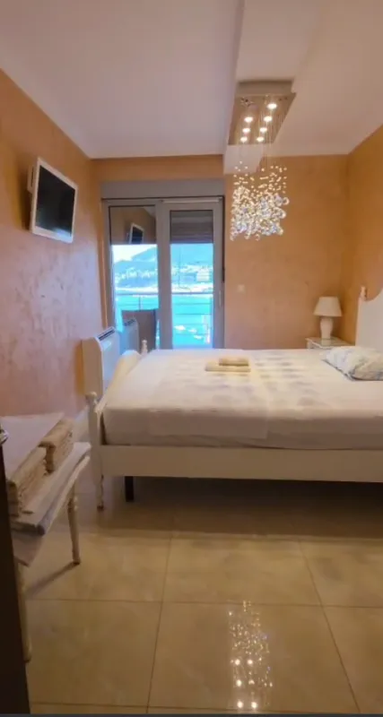 Spavaća soba sa bračnim krevetom i pogledom na more.