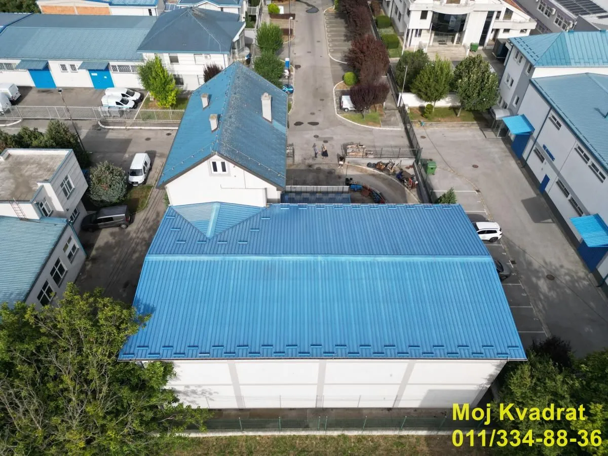 Aerial view of the building and surrounding yard with parking.
