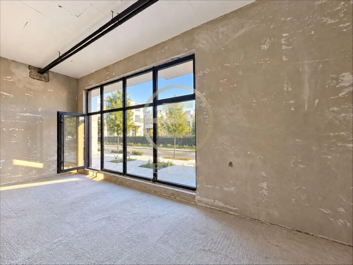 Unfinished commercial space with large windows and street view.