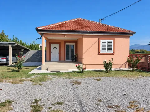 View of the front of the house with a covered terrace, yard, and parking area. - image 3