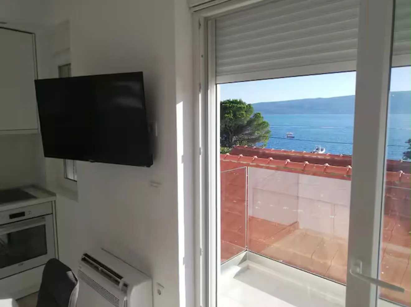 Dnevni boravak sa televizorom i pogledom na more.