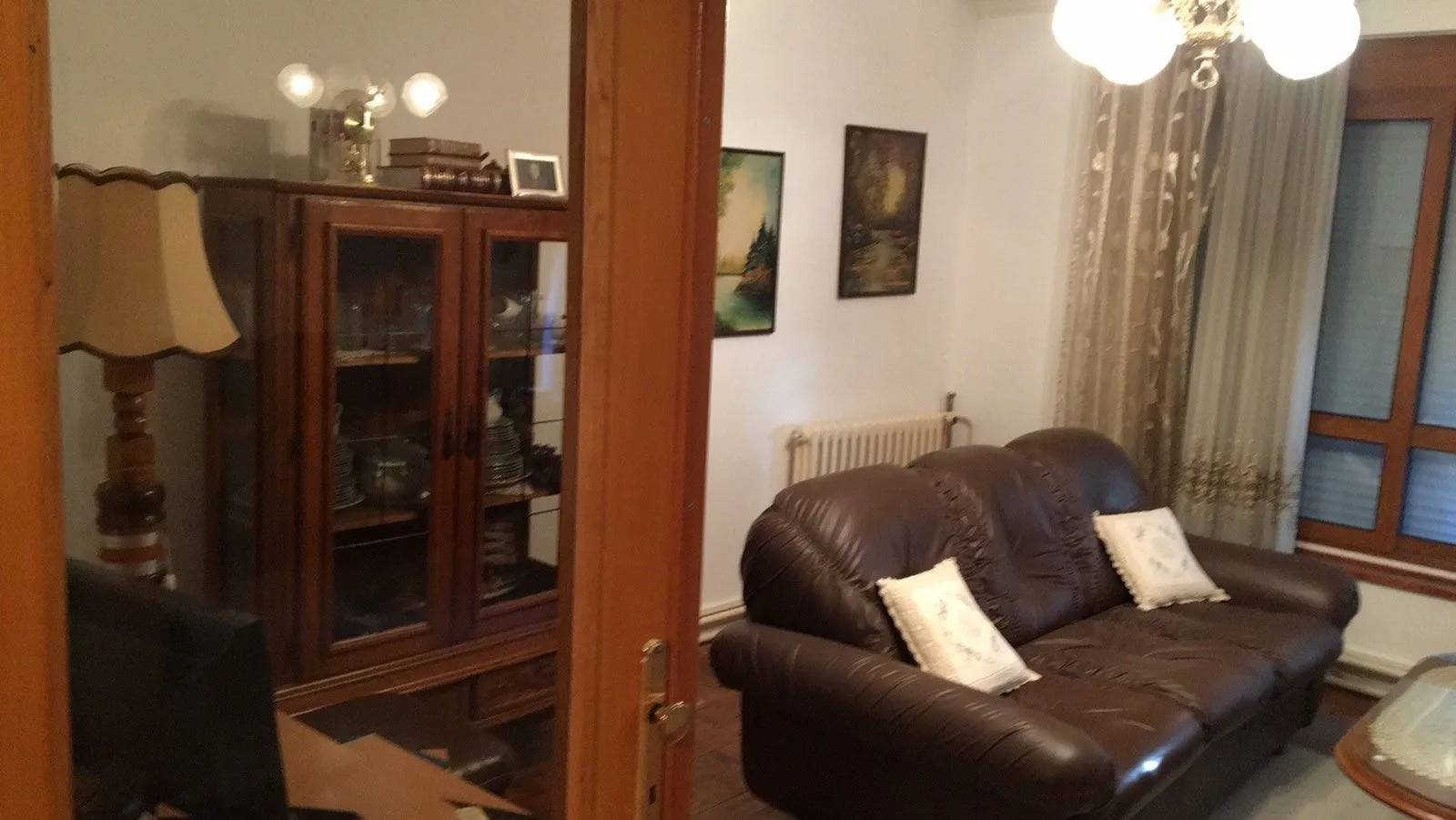Living room with a leather sofa and wooden furniture.