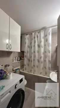 Small bathroom with a bathtub, washing machine, and a white cabinet. - image 20