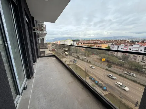 Prostrana terasa sa staklenom ogradom i pogledom na gradsku ulicu. - image 13