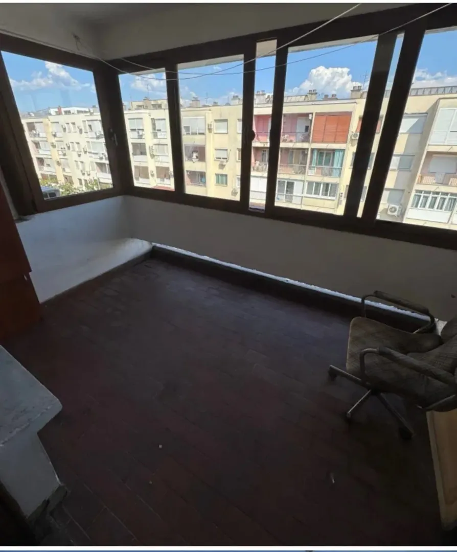 Enclosed balcony with a view of neighboring buildings.