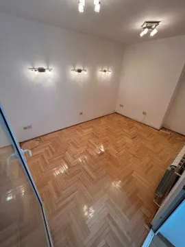Prazna prostorija sa parketom i rasvetom na zidovima. - image 3