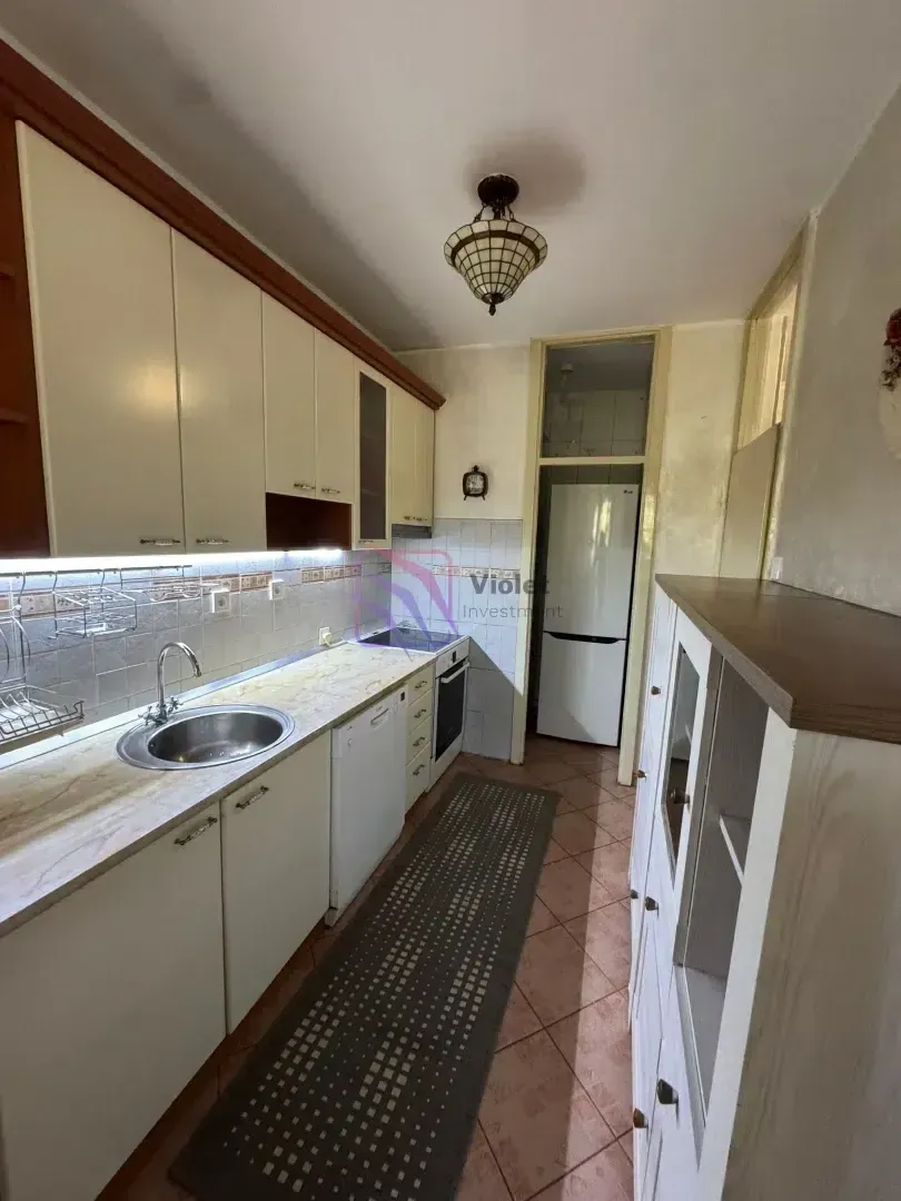 Small kitchen with white cabinets, a sink, and a built-in stove.