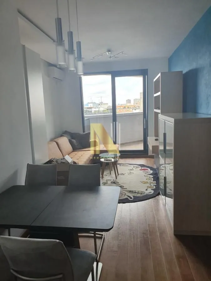 Dnevna soba sa trpezarijskim stolom i izlazom na terasu.