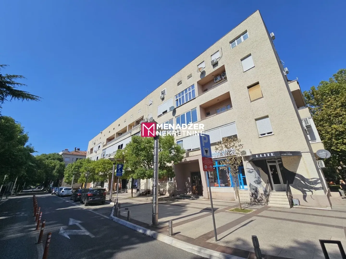 Eksterijer stambene zgrade sa poslovnim prostorom u prizemlju.