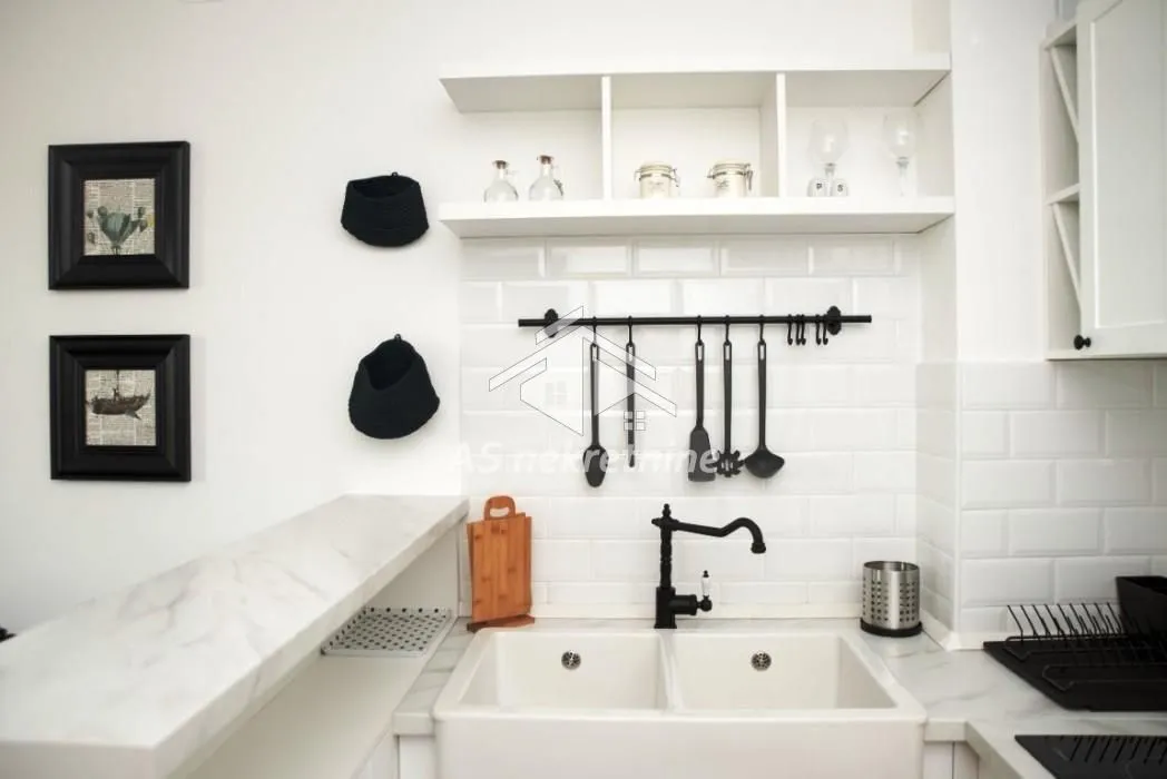 Small kitchen with white cabinets and a double sink.