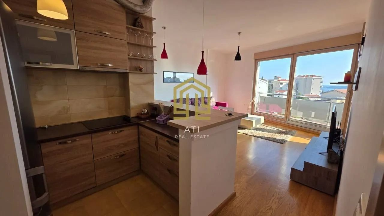 Moderna kuhinja povezana sa dnevnim boravkom i pogledom na more.