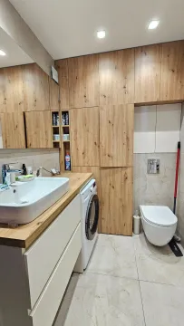 Moderne kupatilo sa umivaonikom, veš mašinom, ugradnim plakarima i toaletom. - image 8